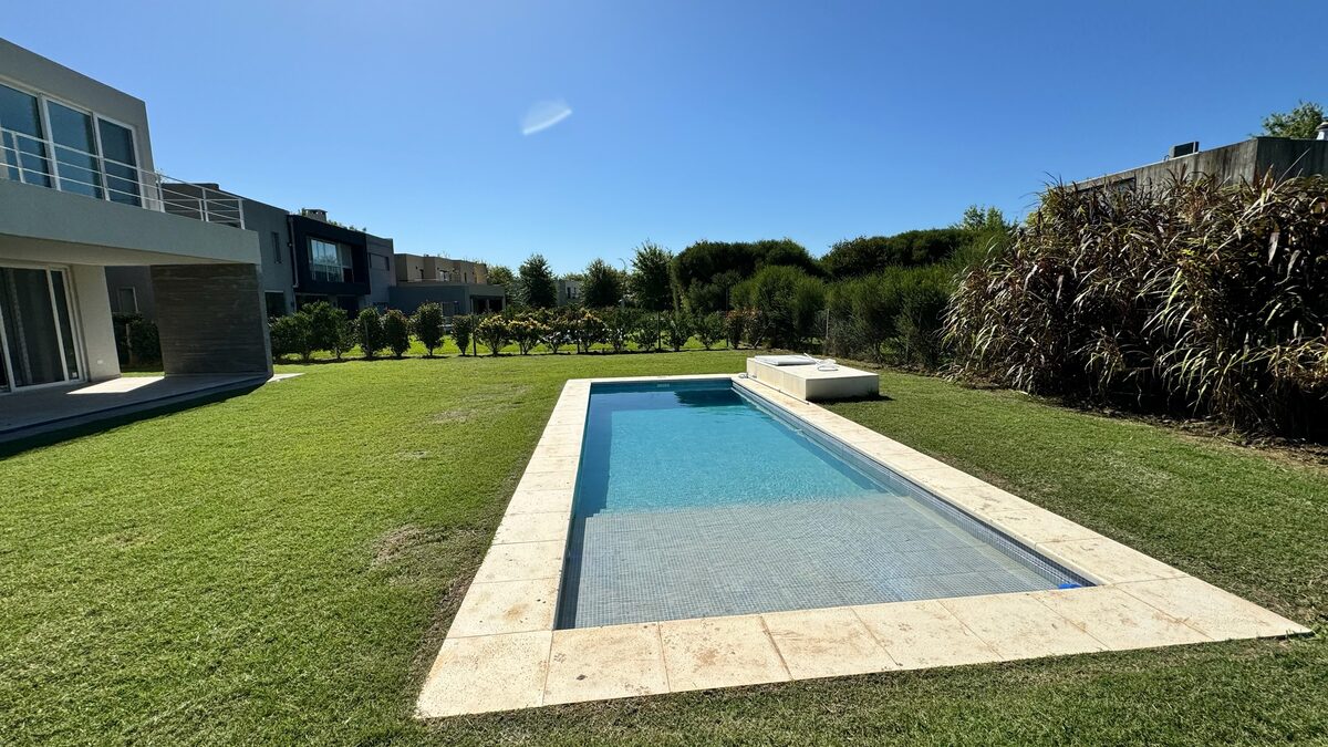 Pileta con solado de travertino y parque terminado, junto a la vivienda, en Haras de Santa María.